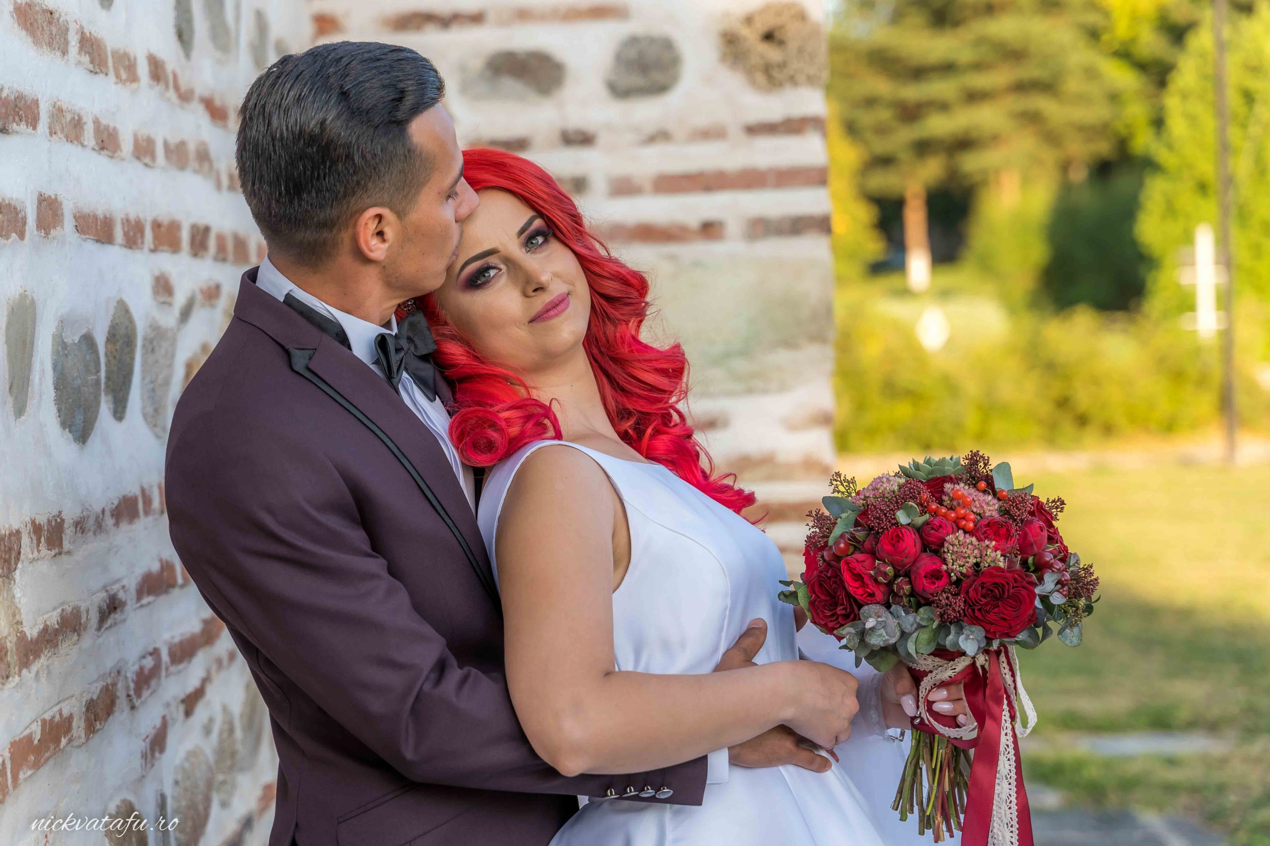 Mire și mireasă zâmbind, îmbrățișați cu emoție, fotografia de nuntă surprinsă într-un decor natural.