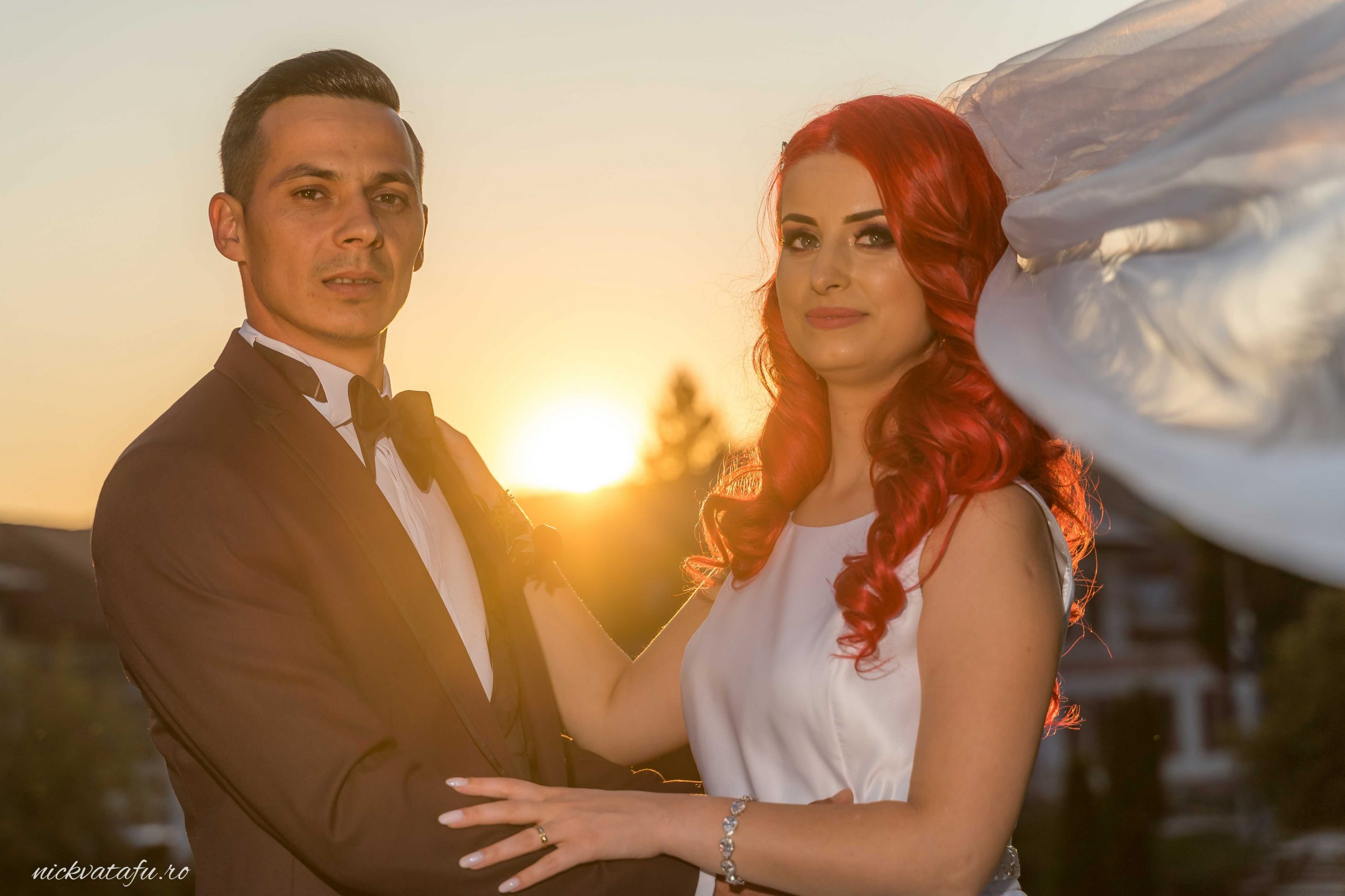 Mire și mireasă în lumina apusului, radiind emoție și eleganță, fotografie de nuntă captivantă.