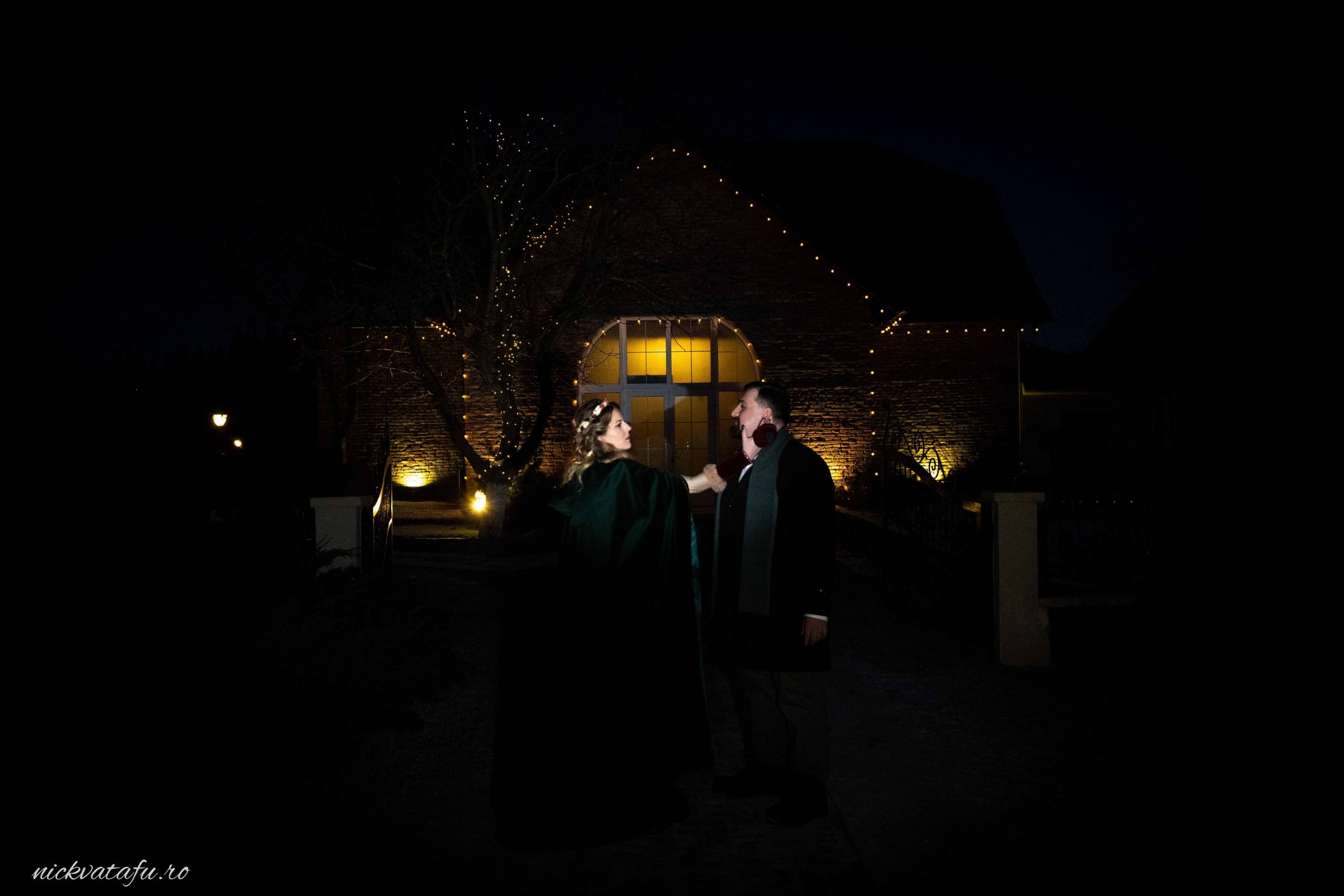 Mire și mireasă admirând luminițele de la nuntă, într-o atmosferă romantică, fotografie de nuntă nocturnă.