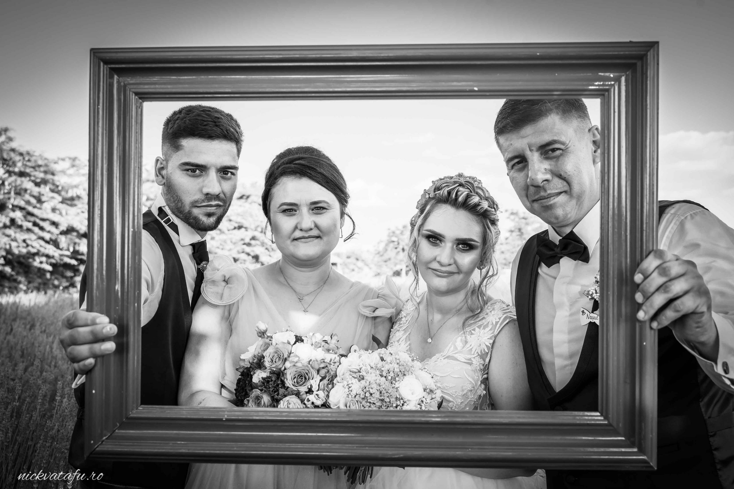 Mire și mireasă alături de prieteni, zâmbete pline de emoție, fotografie de nuntă cu un cadru elegant.