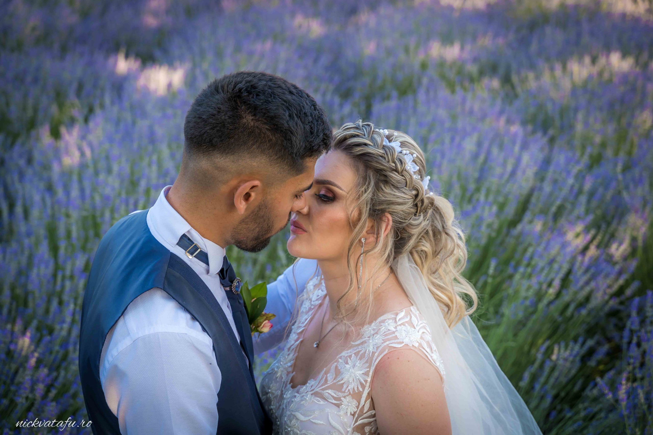 Mire și mireasă împărtășind un sărut plin de emoție, înconjurați de lavandă, fotografie de nuntă romantică.