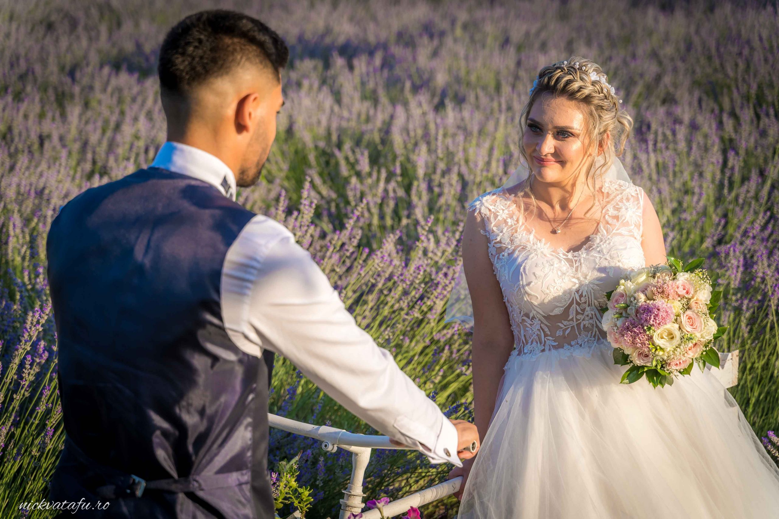 Mire și mireasă privesc emoționați unul către altul, înconjurați de lavandă, fotografie nuntă plină de romantism.