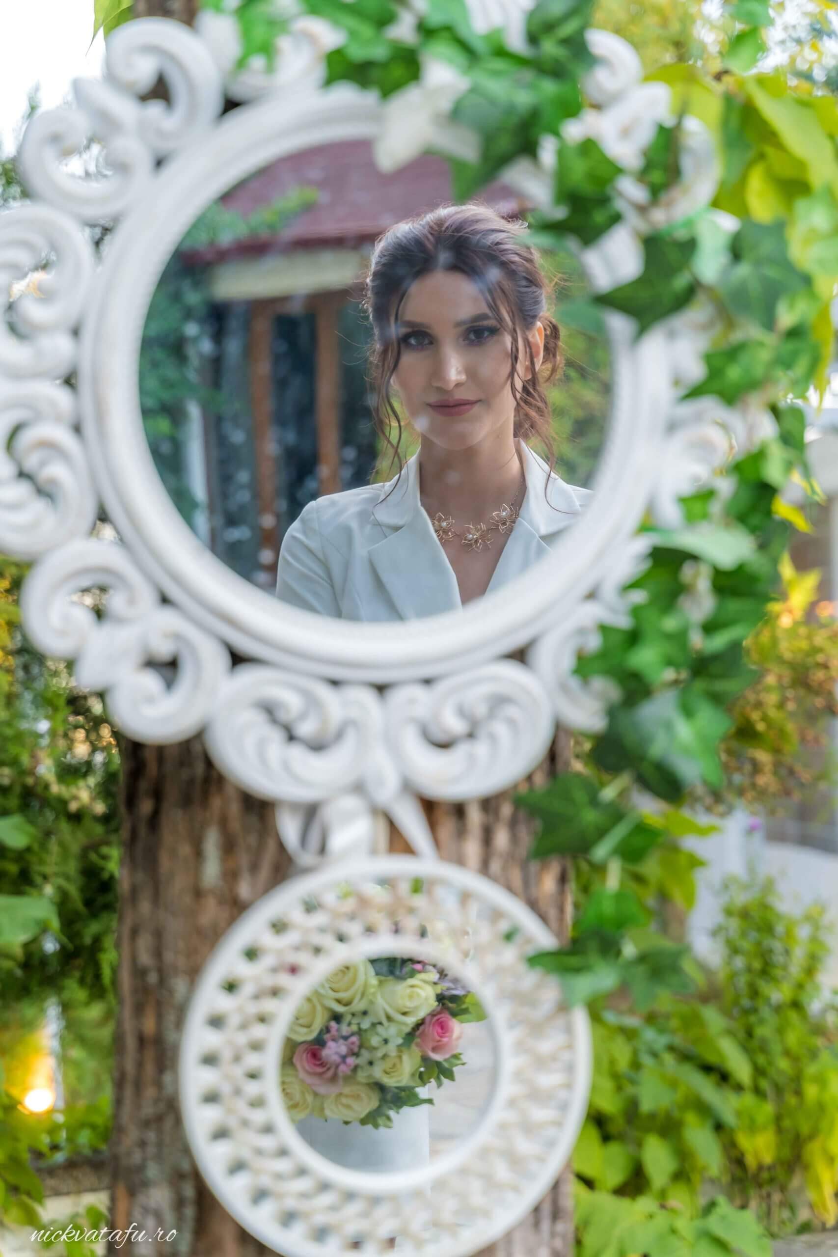 Reflexie elegantă a miresei într-un cadru natural, capturând emoția unui moment special de nuntă.