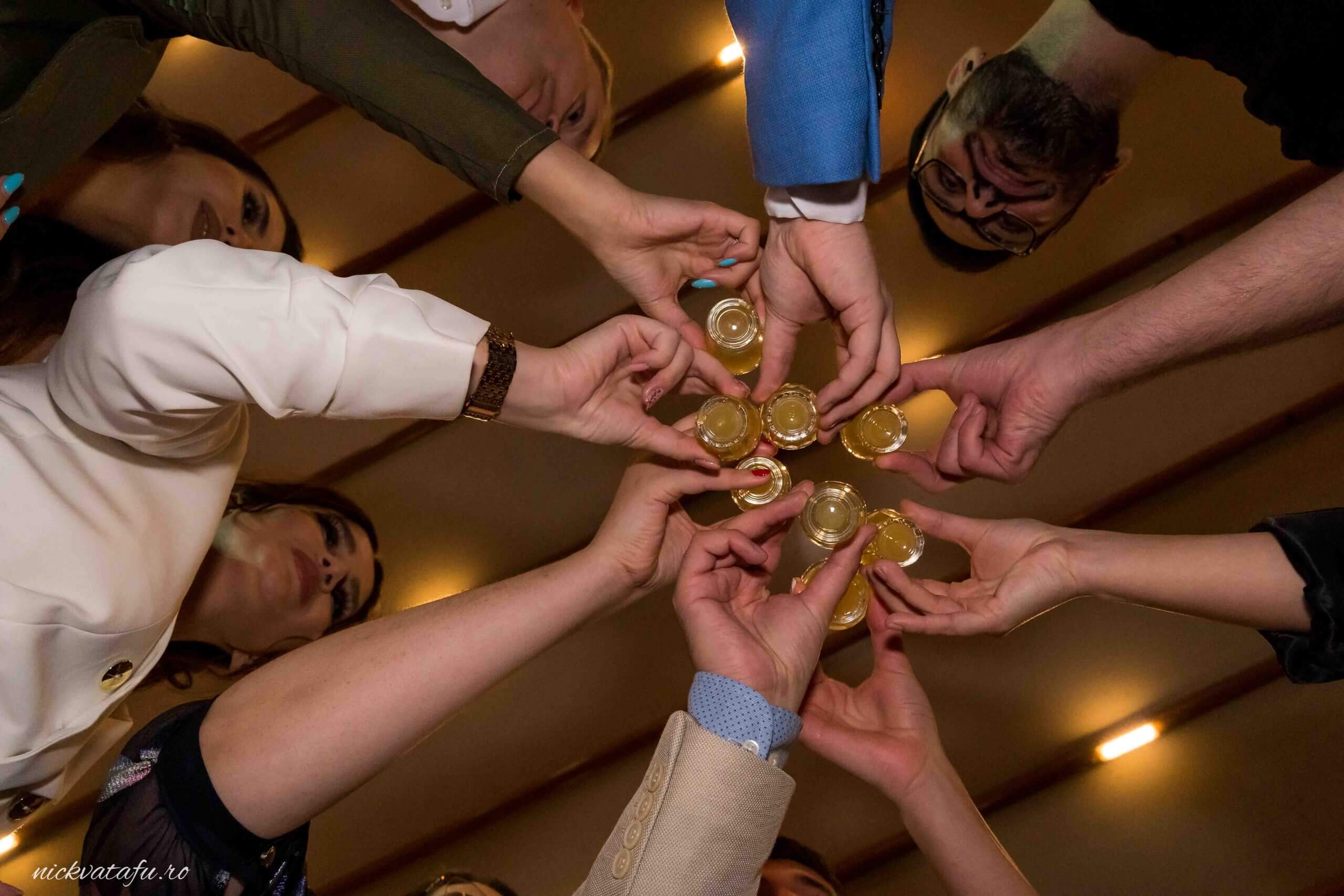 Mâini care se unesc pentru a sărbători, cu pahare de șampanie, în cadrul unei nunți festive.